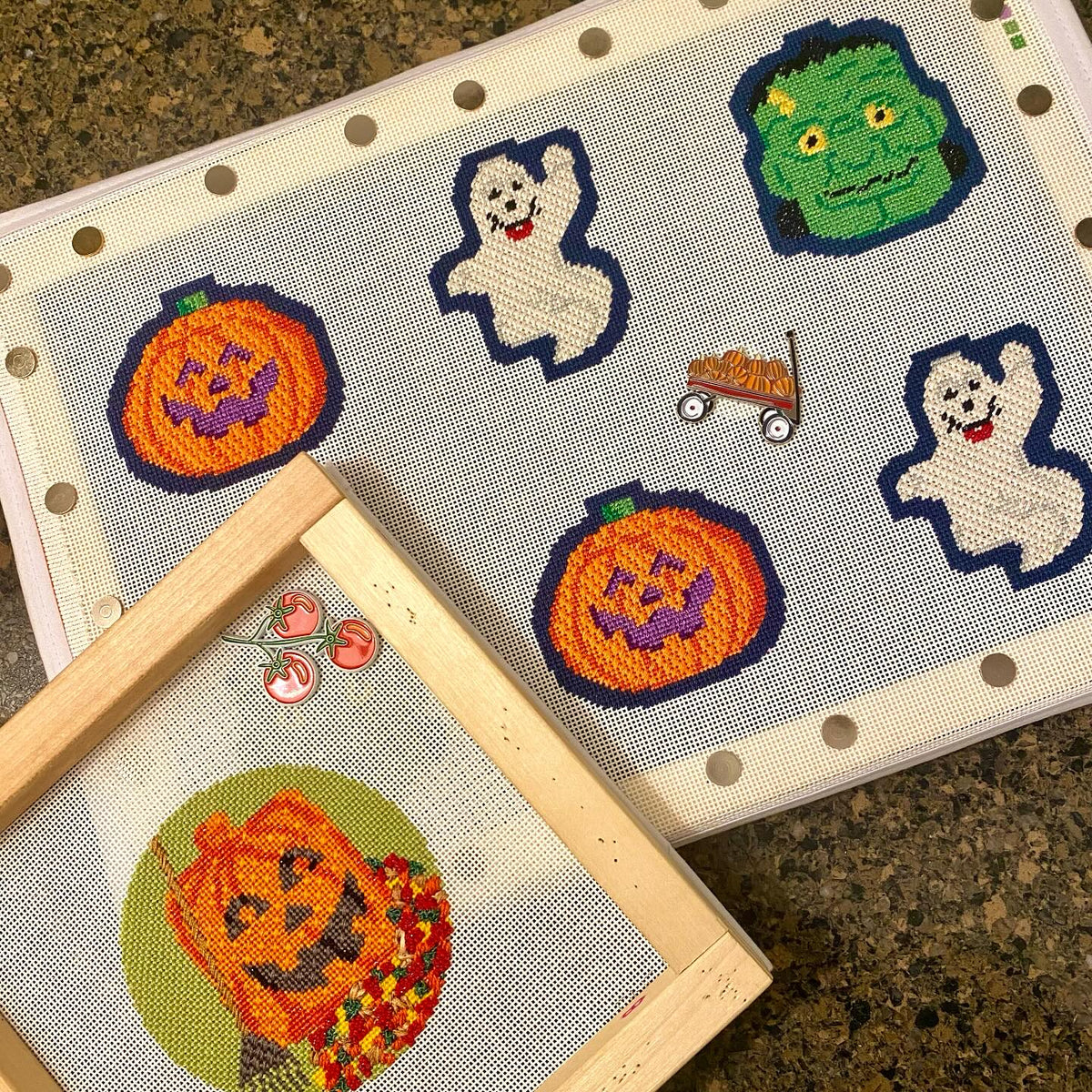 Halloween needlepoint pieces being stitched on stretcher bars from @pinpointneedlepoint on Instagram
