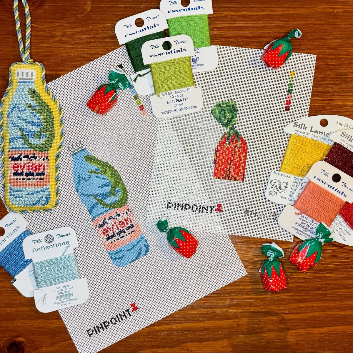 Needlepoint canvases and thread fibers laid out ready for kitting from @pinpointneedlepoint on Instagram