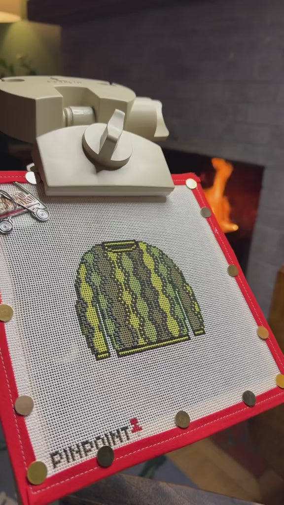 Stitching a Pinpoint sweater canvas by the fireplace
